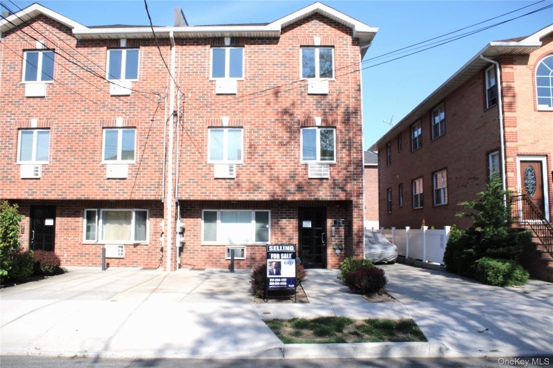Three-story brick exterior featuring multiple windows with white trim