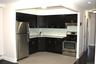 Kitchen featuring dark wood-finish cabinetry, light-toned countertops, a full stainless steel appliance package, and a subway tile backsplash