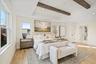Bedroom with multiple windows, light wood finished floors, beamed ceiling, and recessed lighting