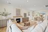 Living room with light wood finished floors, a premium fireplace, recessed lighting, plenty of natural light, and crown molding