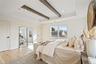 Bedroom featuring beam ceiling, light wood-type flooring, a closet, recessed lighting, and a tray ceiling