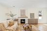 Living room featuring a high end fireplace, recessed lighting, light wood-style floors, crown molding, and a decorative wall