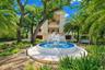 Gated estate entry with grand motor court and fountain arrival.