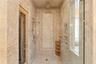 The main-level primary suite serves as a private retreat, featuring a spa-inspired marble ensuite bath with Phylrich fixtures, a large sauna, soaking 