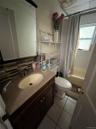 Bathroom with toilet, vanity, tasteful backsplash, shower / tub combo with curtain, and tile patterned flooring