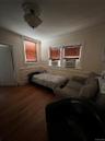 Bedroom featuring cooling unit, wood finished floors, crown molding, and a baseboard radiator