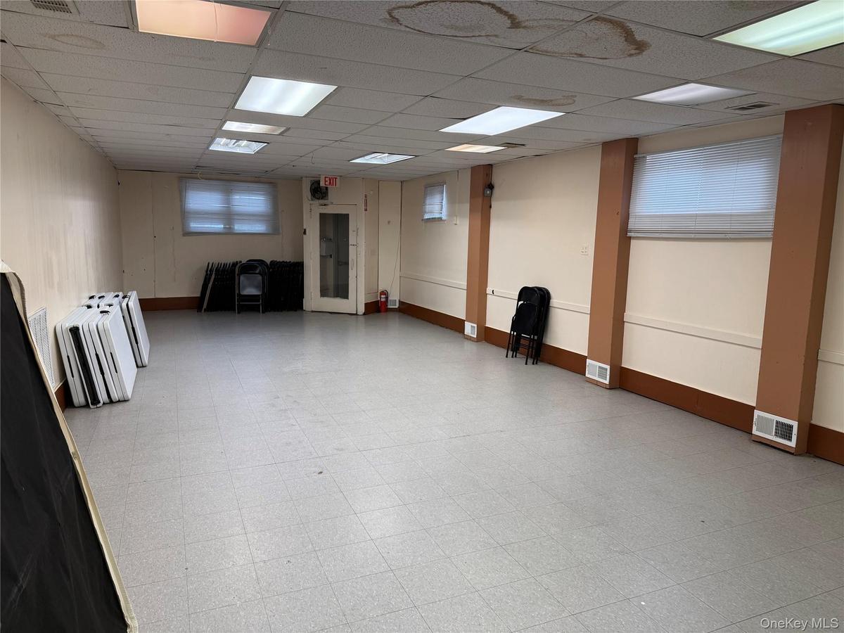 Below grade area featuring tile patterned floors, visible vents, and baseboards
