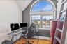 Office space with light wood-style floors, healthy amount of natural light, and lofted ceiling