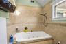 Bathroom featuring tile walls, a combined bath / shower with jetted tub, and lofted ceiling