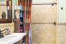Full bath with decorative backsplash, a shower with curtain, and vanity