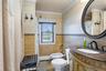 Full bath featuring tile walls, vanity, a bidet, a baseboard heating unit, and crown molding