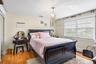 Bedroom featuring light wood-style floors, baseboard heating, a chandelier, and a closet