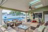 Fenced backyard with outdoor lounge area, a patio, and a ceiling fan