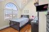 Bedroom featuring lofted ceiling, wood finished floors, baseboard heating, and a chandelier