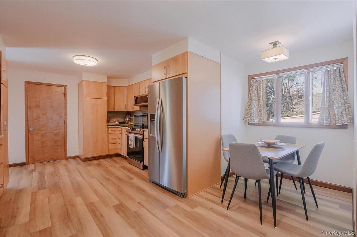 First floor custom kitchen features beautiful wood cabinetry, granite countertops, a stylish backsplash, and rich wood floors, combining warmth, elega