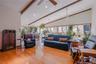 This stunning family room showcases beautiful hardwood floors and numerous windows that flood the space with natural light, offering a bright and welc