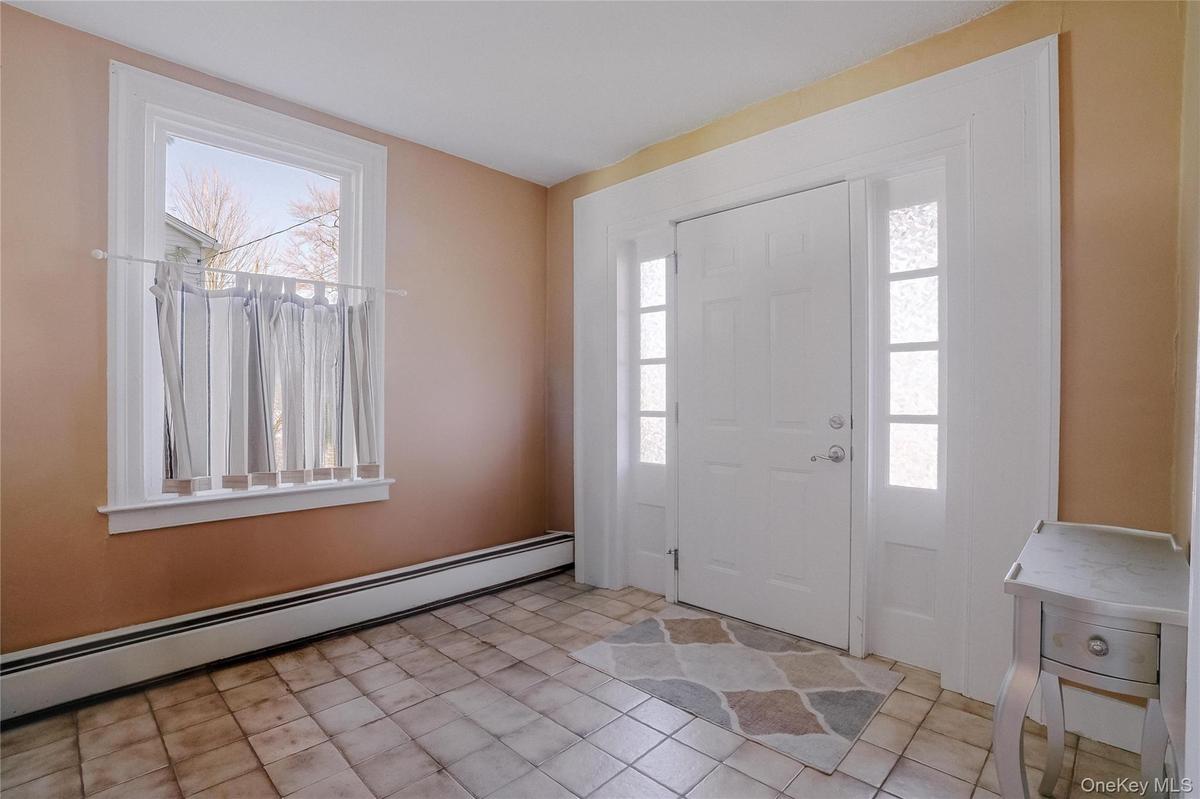 Step into a spacious tiled foyer that creates a warm and inviting first impression, welcoming you into the expansive first-floor unit with comfort and