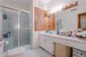 The first-floor primary bathroom features beautiful tilework, a spacious walk-in shower, and a built-in vanity, creating a stylish and functional spac