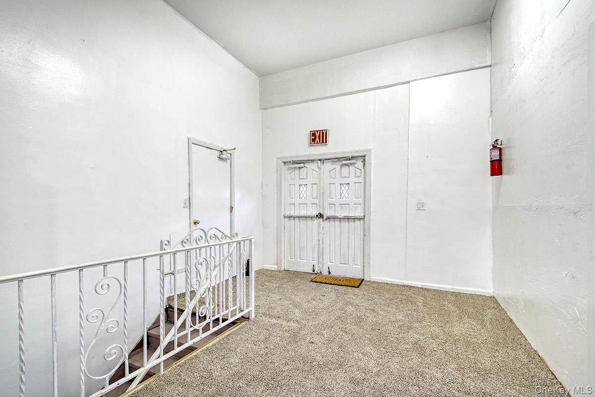 Hallway with carpet flooring and an upstairs landing