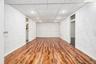 Unfurnished room with a textured wall, stacked washer / dryer, wood-type flooring, baseboards, and a drop ceiling