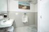 Bathroom with tile walls, a sink, and wainscoting