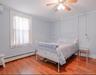 This spacious bedroom features beautiful hardwood floors and two generous closets, offering both charm and ample storage space.