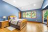 Bedroom featuring access to exterior, light wood finished floors, and lofted ceiling