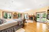 Bedroom with light wood-type flooring, access to outside, lofted ceiling, a fireplace, and recessed lighting
