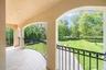 Patio / terrace featuring view of wooded area and a lawn
