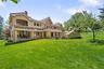 Back of property with a chimney, stucco siding, a lawn, and a tile roof