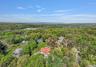 Aerial view of property and surrounding area with a forest