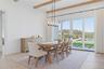 Dining area with wood-finish flooring and exposed ceiling beams