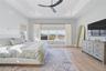 Spacious room featuring wood-finish flooring, a tray ceiling with recessed lighting, and a modern ceiling fan