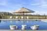 Inground swimming pool with a stone coping and a paved surround