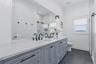 Dual sink vanity featuring light gray cabinetry, white countertop, and matte black fixtures