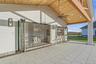 Expansive outdoor living area featuring a wood-finished vaulted ceiling, overhead fan, recessed lighting, and a built-in bar with bifold windows