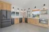 Modern kitchen featuring light wood cabinetry, a large matte black refrigerator, and an expansive pass-through window