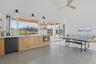 Spacious room featuring vaulted ceilings, shiplap wall finishes, and polished concrete flooring