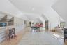 Spacious room featuring wood-finish flooring, recessed lighting, and built-in storage cabinetry