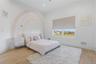 Well-lit interior featuring a broad window, light wood-finish flooring, white walls, and a built-in recessed ceiling light fixture
