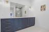 Dual vanity featuring a white countertop, blue cabinetry, and gold-finish hardware