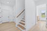 Foyer featuring light wood-finish flooring and a staircase with wood treads and handrail