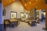 Covered outdoor patio featuring a stone-clad fireplace and wood-finish vaulted ceiling