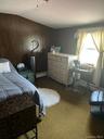 Room featuring wood paneling, a ceiling-mounted light fixture, and a window with natural light