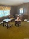 Room featuring wood paneling, wall-to-wall carpeting, and multiple windows with blinds