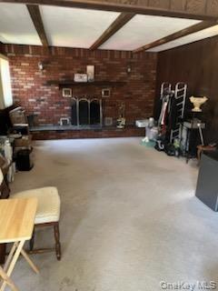 Brick fireplace with a dark wood mantel and a decorative fire screen
