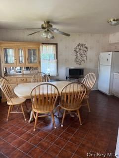 Dining area featuring ceramic tile flooring, a window with natural light, and a ceiling fan with integrated lighting