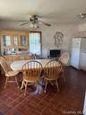Dining area featuring ceramic tile flooring, a window with natural light, and a ceiling fan with integrated lighting