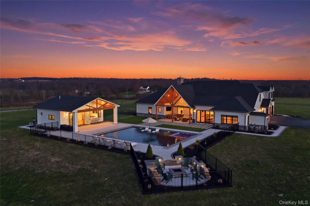 Modern exterior featuring white siding, dark roofing, and exposed wood beam accents