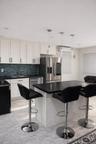 Kitchen with a kitchen bar, light marble finish flooring, pendant lighting, and tasteful backsplash